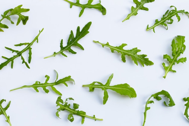 Insalata di rucola verde fresca su priorità bassa bianca.