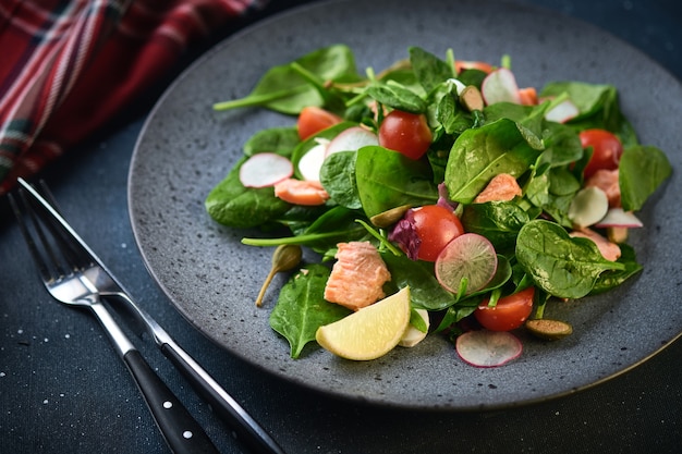 Insalata Di Salmone Affumicato. Mangiare sano Insalata saporita con pesce rosso, ravanello e pomodorini.