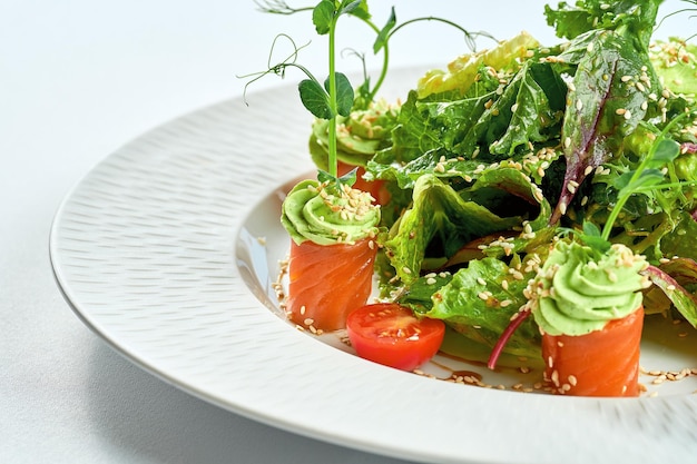 Insalata di salmone con mousse di avocado in un piatto bianco