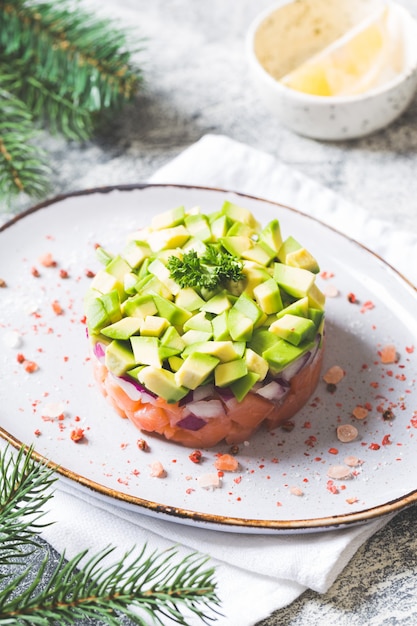 Insalata di salmone crudo, avocado e cipolla viola. tartare di salmone. antipasto per la tavola di Capodanno o Natale