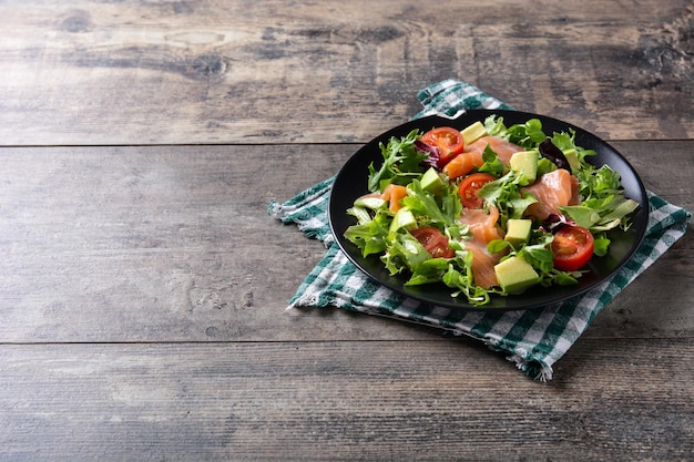 Insalata di salmone e avocado su tavola in legno rustico