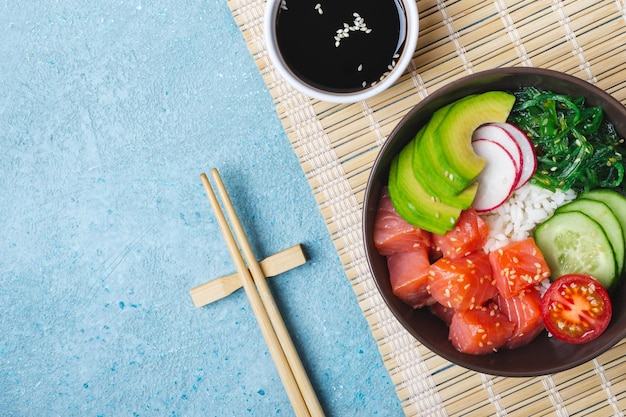 Insalata di salmone hawaiano con riso, bacchette e salsa di soia. Ciotola di sushi.