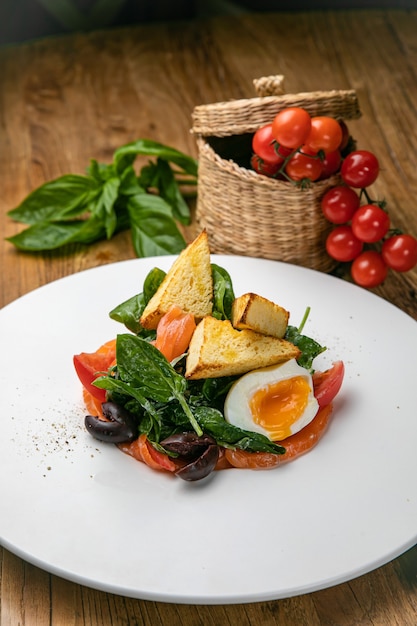 Insalata di salmone su un piatto con uova ed erbe aromatiche