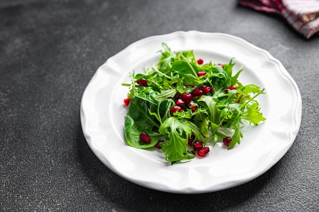 insalata di semi di melograno foglie verdi mix di lattuga pasto sano spuntino sullo spazio della copia del tavolo