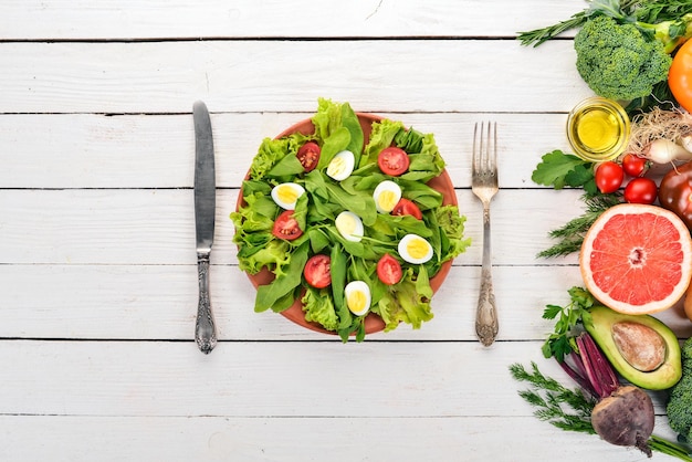 Insalata di spinaci e uova di quaglia su sfondo di legno Cibo sano Vista dall'alto Spazio di copia