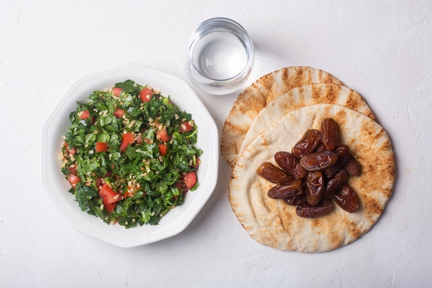 Insalata di tabbouleh, pane, datteri e acqua - piatto tradizionale mediorientale o arabo per iftar