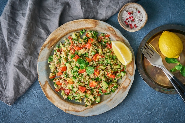 Insalata di tabulé con quinoa. Il cibo orientale con le verdure si mescola al buio