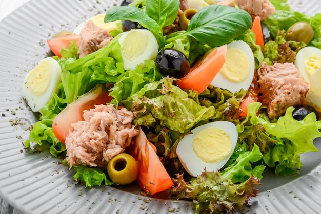 Insalata di tonno con pomodori, olive, uova e cipolla.