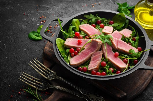 Insalata di tonno con rucola e avocado su una lastra di pietra nera Vista dall'alto Spazio libero per il testo