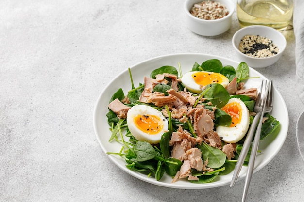 Insalata di tonno con uova sode e spinaci su piatto bianco Dieta Keto Cibo sano Insalatiera fresca Cena