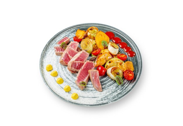 Insalata di tonno e verdure, mango, porri e pomodorini grigliati con salsa su fondo bianco isolato