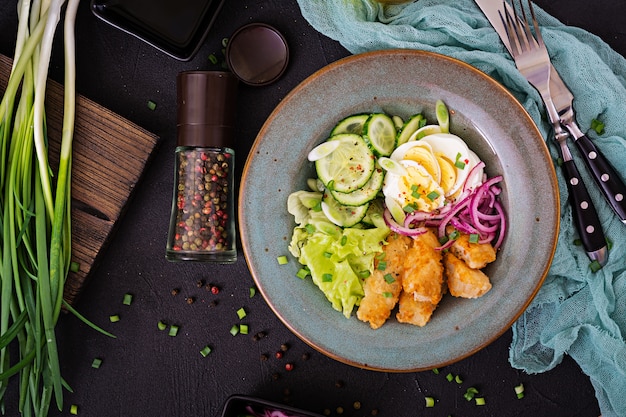 Insalata di uova, pesce fritto e verdure fresche. Cucina asiatica. Vista dall'alto