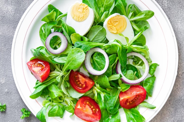 insalata di uova, verdure, pomodoro, cipolla, foglie di lattuga verde mix petali fresco pasto sano cibo spuntino