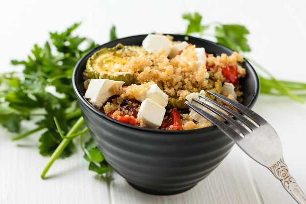 Insalata di verdure al forno con quinoa e formaggio serbo su un tavolo bianco