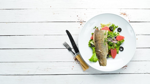 Insalata di verdure al pompelmo e filetto di trota su un piatto Vista dall'alto spazio libero per il testo Stile rustico