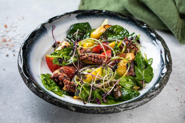 Insalata di verdure ciotola bianca e nera Insalata in una ciotola di vetro su sfondo bianco