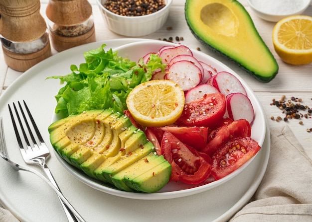 Insalata di verdure con avocado, ravanelli e pomodori in tavola