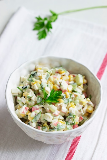 Insalata di verdure con bastoncini di granchio, condita con maionese. Messa a fuoco selettiva.