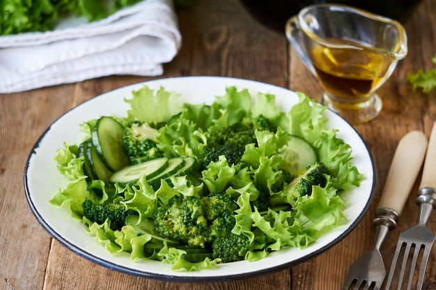 Insalata di verdure con broccoli, cetrioli e lattuga in una ciotola bianca