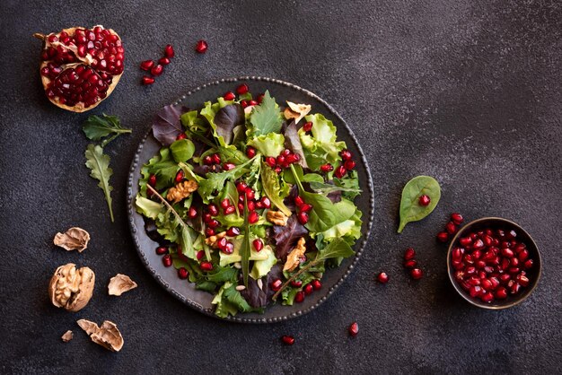 Insalata di verdure con foglie verdi e semi di melograno