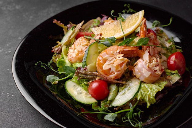 Insalata di verdure con gamberetti su sfondo nero