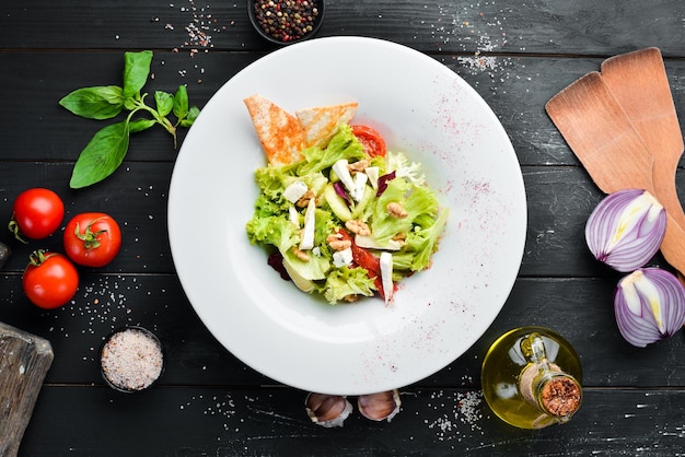 Insalata di verdure con olive al formaggio e pomodorini Nel piatto Vista dall'alto Spazio libero per il tuo testo Stile rustico