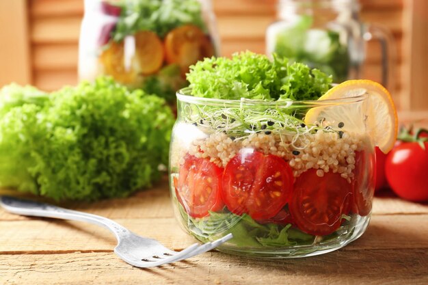 Insalata di verdure con quinoa servita in barattolo di vetro sul tavolo della cucina