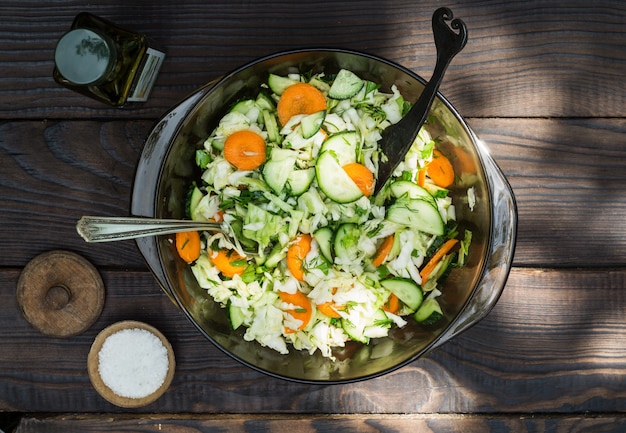 Insalata di verdure crude affettate sul tavolo di legno