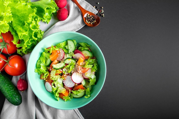 Insalata di verdure di stagione da prodotti agricoli biologici su sfondo grigio