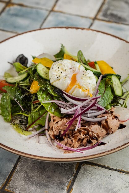 Insalata di verdure e uova con piatto fondo di zuppa fredda di okroshka con kvas su un piatto bianco