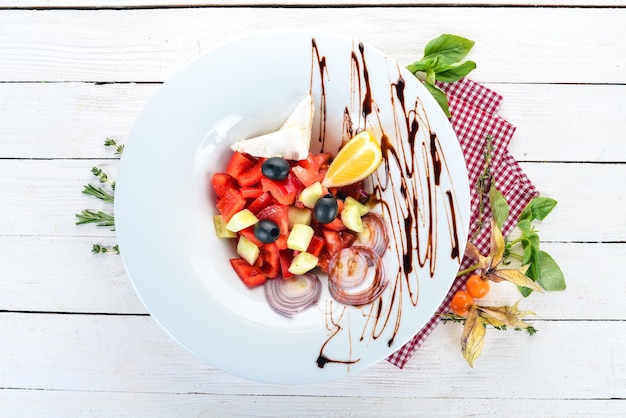 Insalata di verdure greca con formaggio brie su sfondo di legno Vista dall'alto Spazio di copia