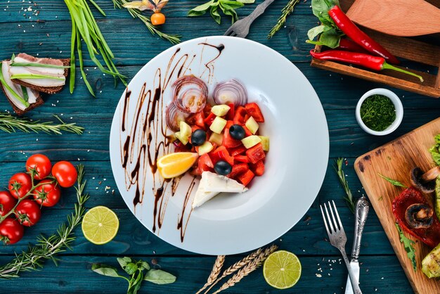 Insalata di verdure greca con formaggio brie su sfondo di legno Vista dall'alto Spazio di copia