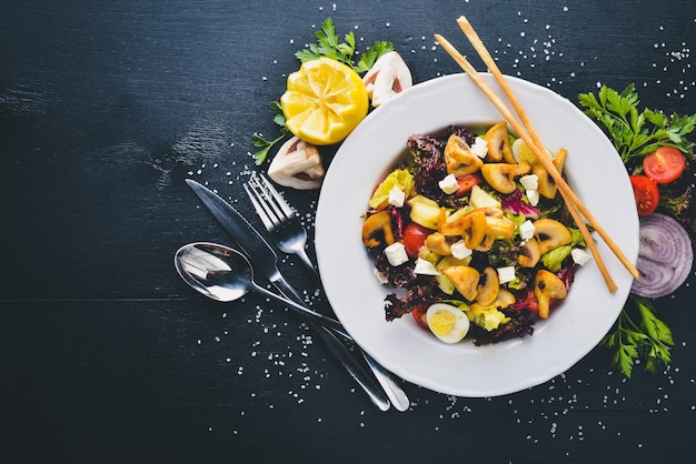 Insalata di verdure grigliate Funghi Feta e olio d'oliva Su una superficie di legno nera Spazio libero per il testo Vista dall'alto