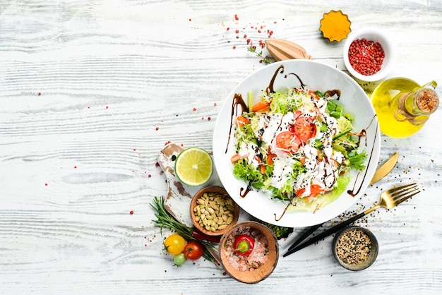 Insalata di verdure lattuga pomodori cetrioli e salsa di panna Caesar Vista dall'alto Vista dall'alto Stile rustico