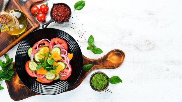 Insalata di verdure Pomodori Cetriolo Cipolle Prezzemolo Vista dall'alto Spazio libero per il testo