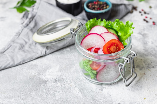 insalata di verdure sano pomodoro, cetriolo, porzione di lattuga mix ravanello sul tavolo