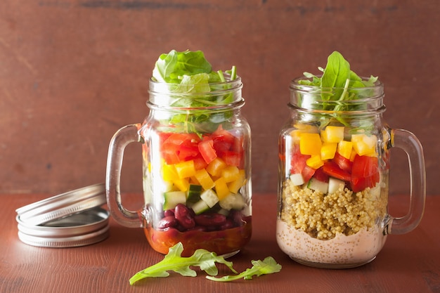 Insalata di verdure vegana con quinoa in barattoli di vetro