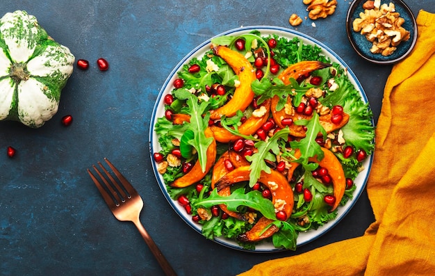 Insalata di zucca autunnale sana e vegana con miele al forno fette di zucca lattuga rucola semi di melograno e noci Comfort food Vista dall'alto