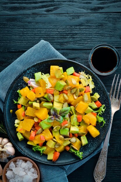 Insalata di zucca avocado e semi di zucca su sfondo nero Vista dall'alto Spazio libero per il testo