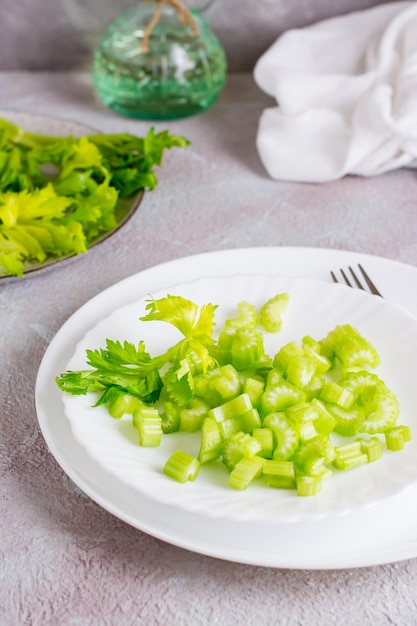 Insalata dietetica di sedano fresco tritato su piatti sul tavolo. Cibo vegetariano. Vista verticale