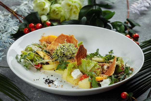 Insalata dietetica estiva con foglie di lattuga, anguria, pesca e feta. Su uno spazio di copia sfondo azzurro.