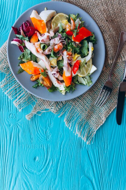 insalata e pasta con frutti di mare su sfondo blu