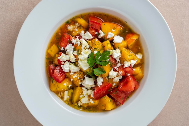 Insalata estiva colorata con pomodoro pesca e formaggio feta da vicino