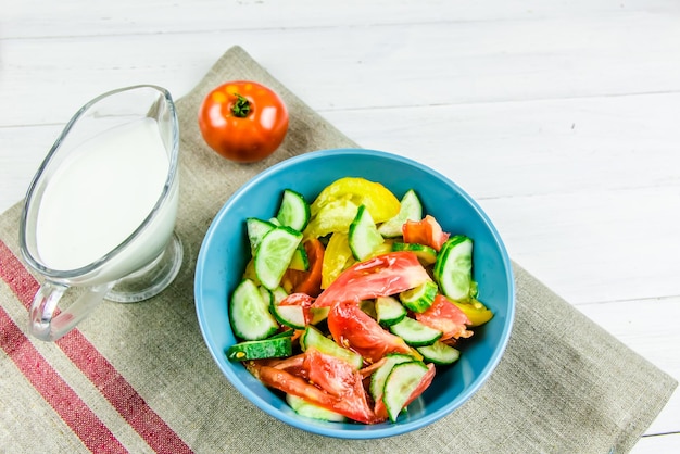 Insalata estiva con cetrioli e pomodori su sfondo bianco