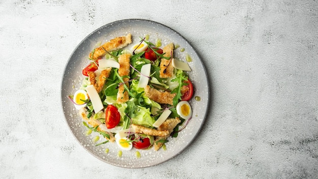 Insalata francese Nicoise con tonno uovo fagiolini pomodori olive lattuga cipolle e acciughe su sfondo bianco Cibo sano