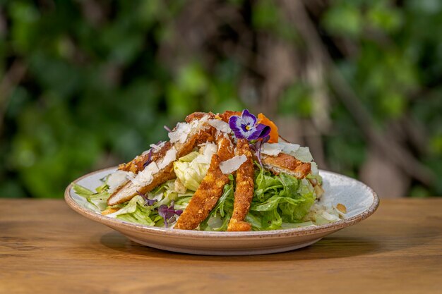 Insalata fresca con petto di pollo su un tavolo di legno