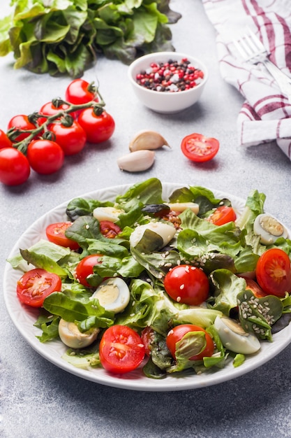 Insalata fresca con pomodori e uova di quaglia e lattuga.