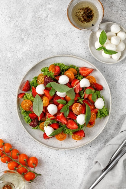 Insalata fresca con pomodorini fragola, mozzarella, ciliegia e basilico Insalata sana e brillante