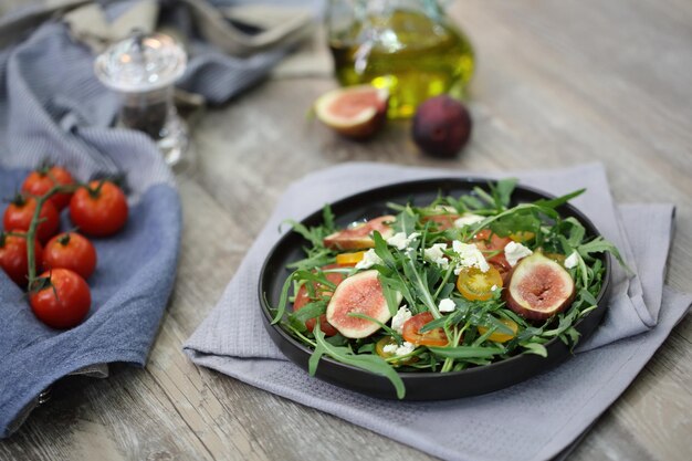 Insalata fresca con rucola pomodoro e formaggio su fondo di legno