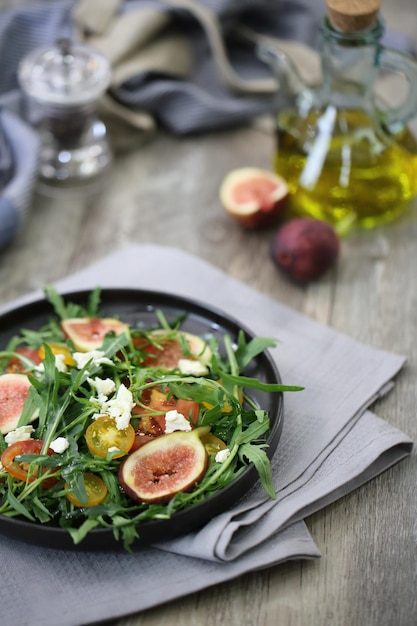 Insalata fresca con rucola pomodoro e formaggio su fondo di legno